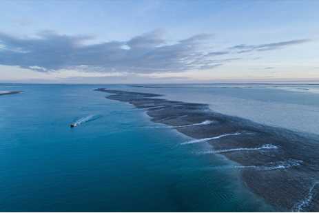 A long long streak of ocean, darkened by the reef underneath